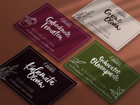 Auf dem Bild sind Etiketten für OlivenZauber GmbH Feinkost zu sehen. Sanja hat hier das Logo designed, die Namen per Hand geschrieben und illustriert. Die Gestaltung ist zu 100% im Studio entstanden. Sanja.Studio | Brand Design