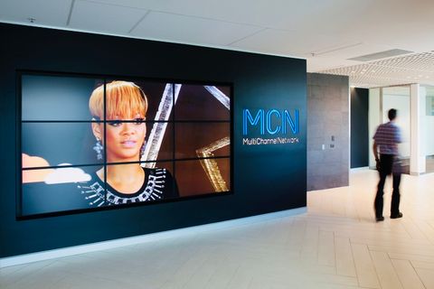 Realisierte Arbeitswelt bei Multi Channel Network: Empfangsbereich mit TV-Wand und Fischgrät-Parkett, als Workplace Strategin entwickelt und geplant