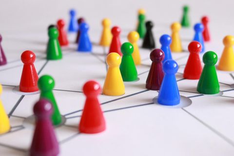 Bunte Spielfiguren auf einem Spielbrett verteilt - Coaching Komplizin