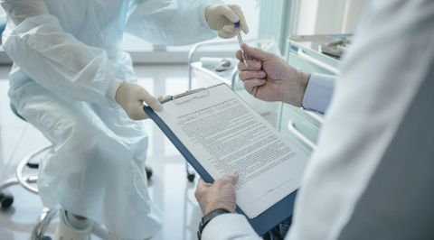 Zwei Labormitarbeiter in weißen Schutzanzügen besprechen ein Dokument in einem modernen Laborumfeld - Datenrettung & Computerservice Andreas Wach