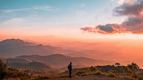 Berglandschaft mit Silhouette einer Person bei Sonnenuntergang - Mut Mach Lehre